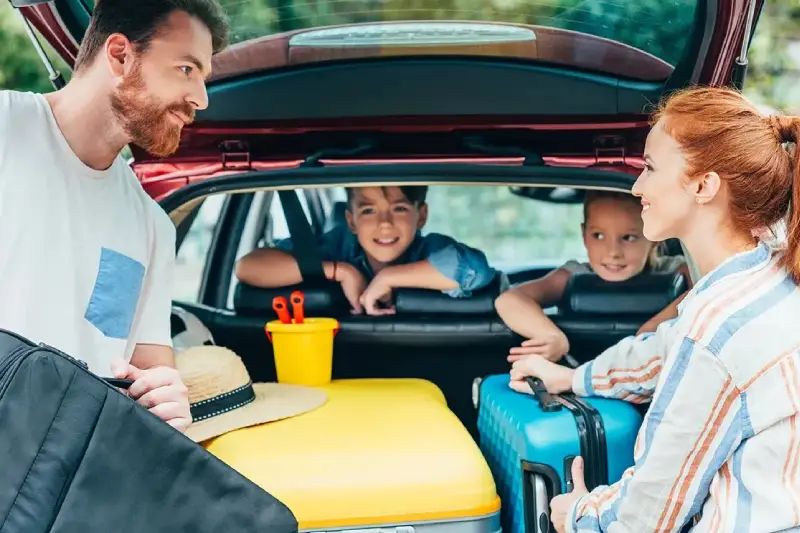 Familia junto a un coche moderno antes de un viaje por carretera